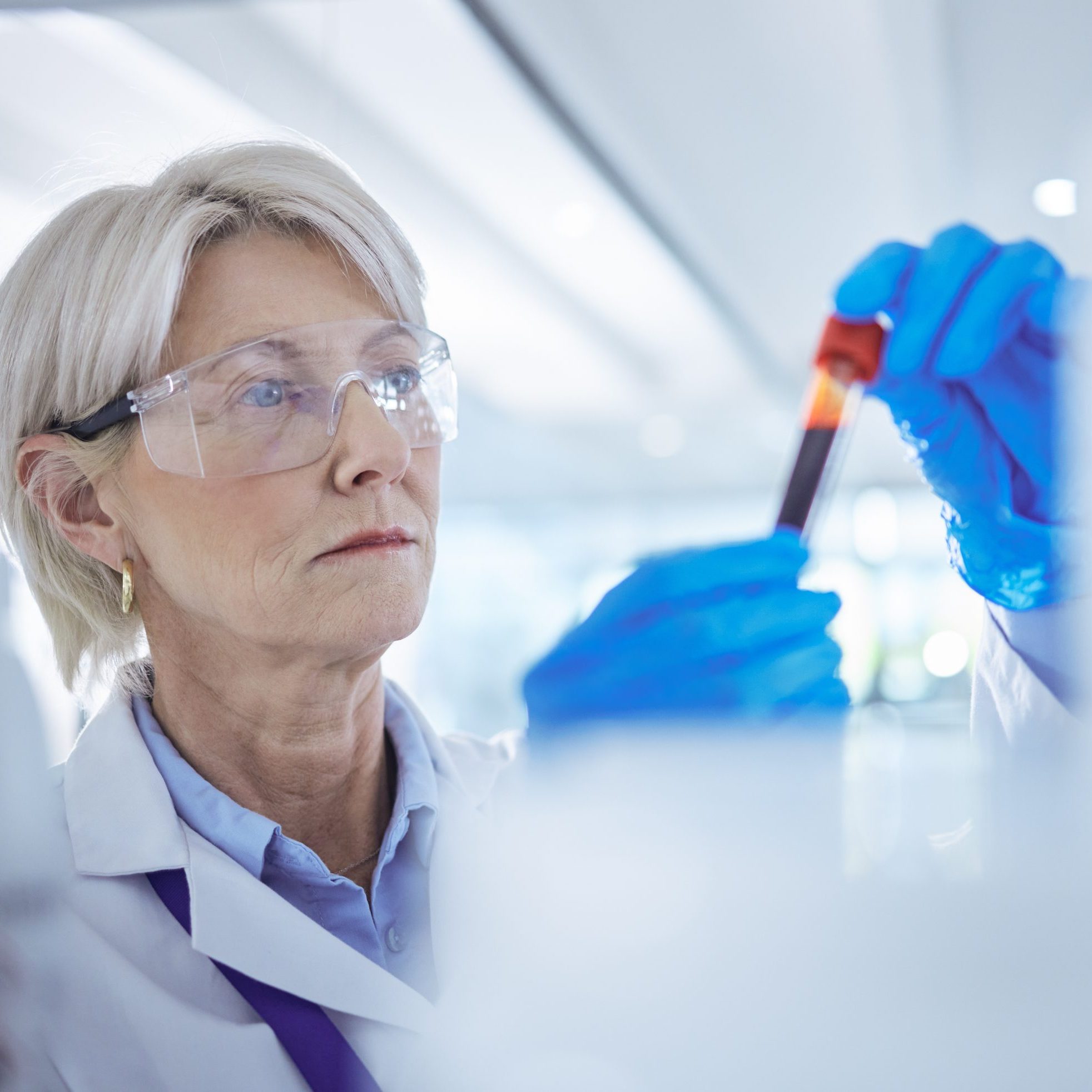 Woman, scientist and medical research with test tube, blood sample and science laboratory for mpox vaccine. Female person, technician and virus in healthcare for chemistry, forensic or pharmaceutical.
